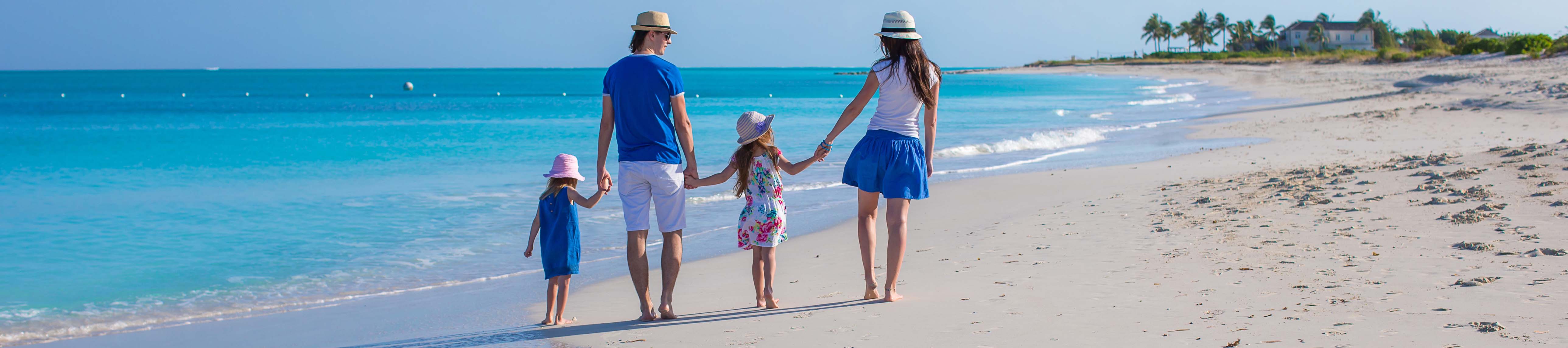 A family holding hands walking on the beach